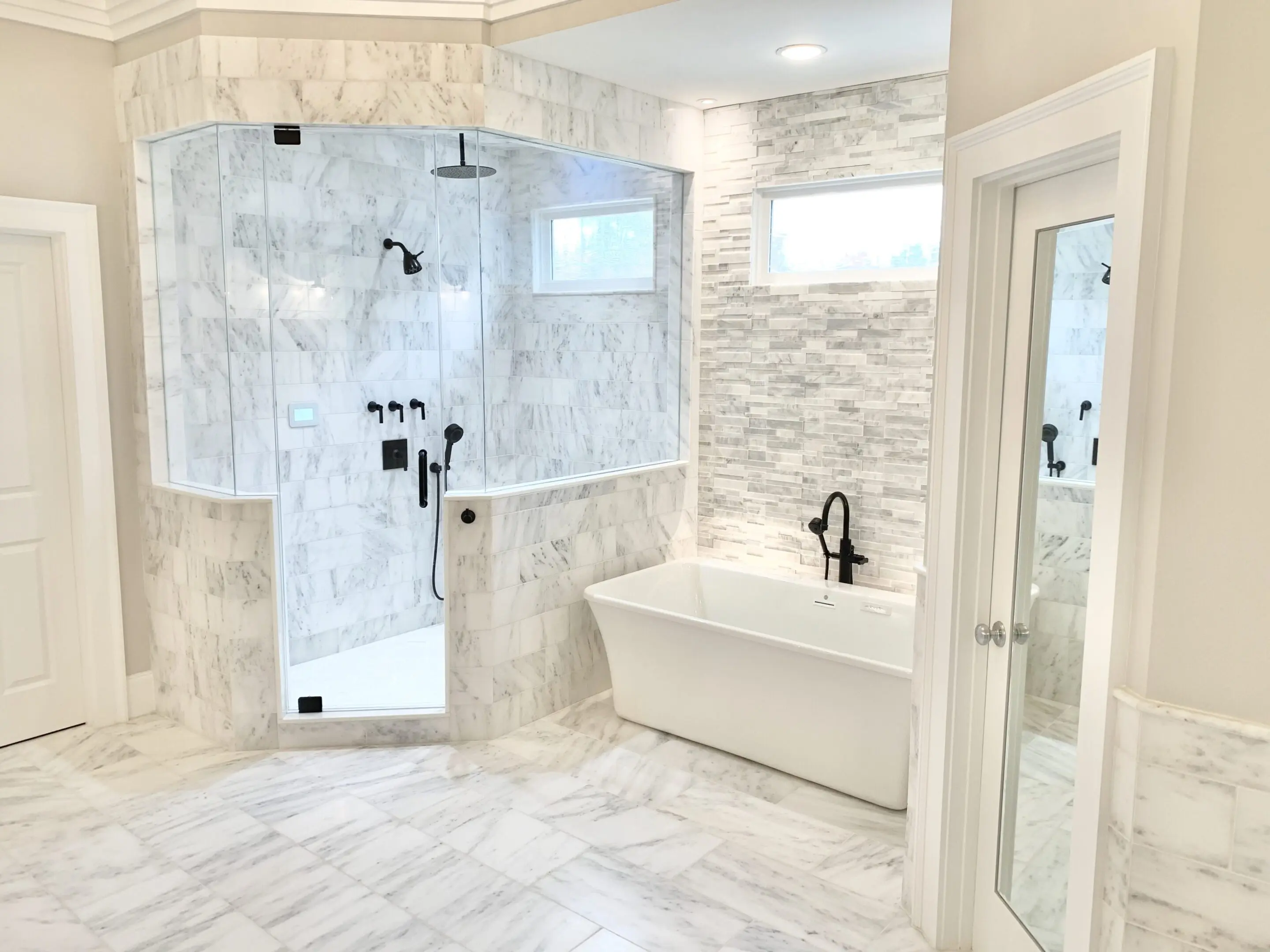 Modern bathroom with glass shower and freestanding tub.